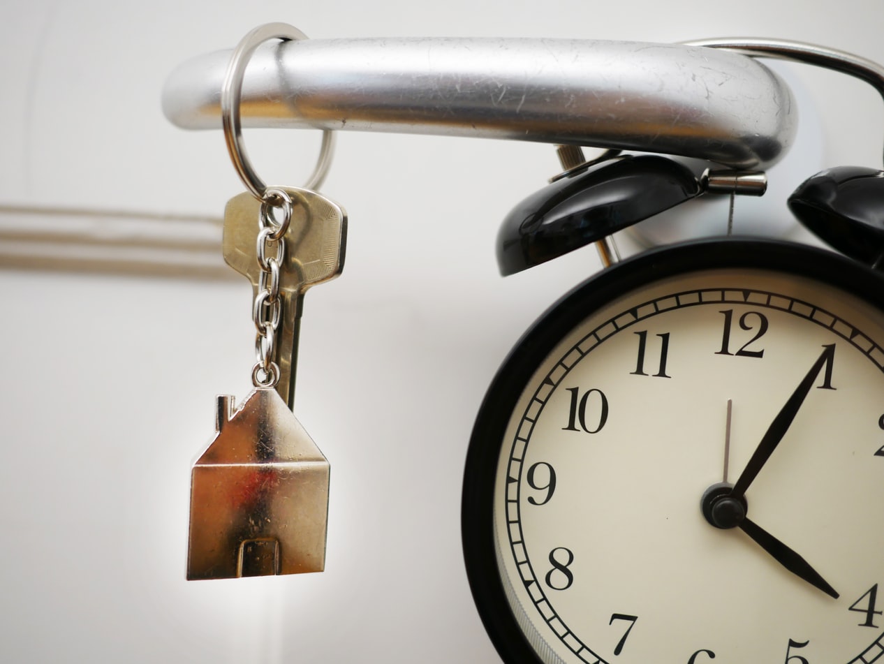 House keys hanging beside an alarm clock before a vacation